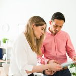 A manager discussing a draft council report with a team member.